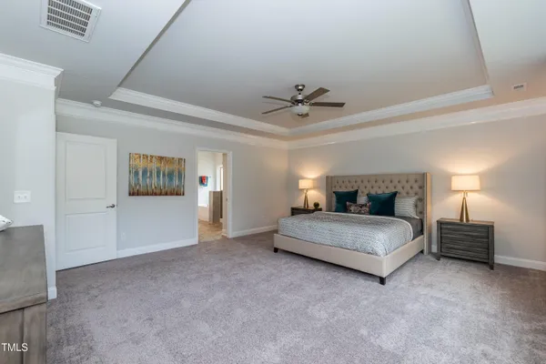 a spacious bedroom with a bed and a lamp