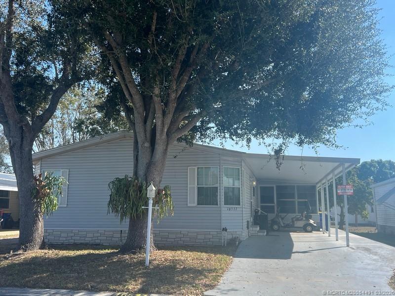 16537 Southwest Two Wood Way Indiantown, FL 34956 - Photo 1 of 14 a front view of a house with garden