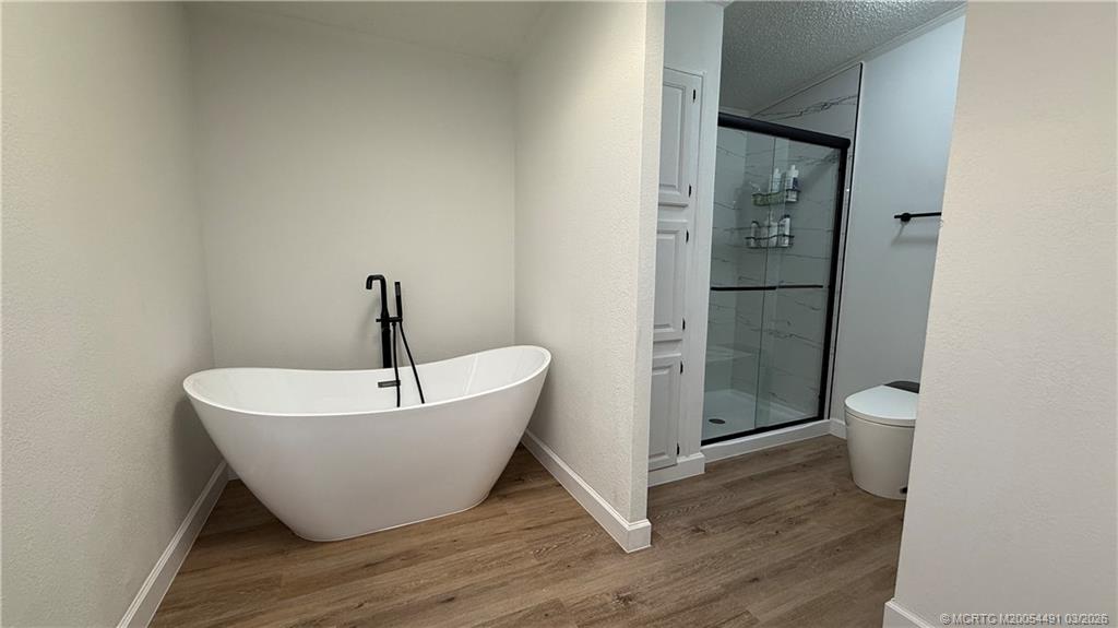 16537 Southwest Two Wood Way Indiantown, FL 34956 - Photo 14 of 14 a spacious bathroom with a bathtub and toilet