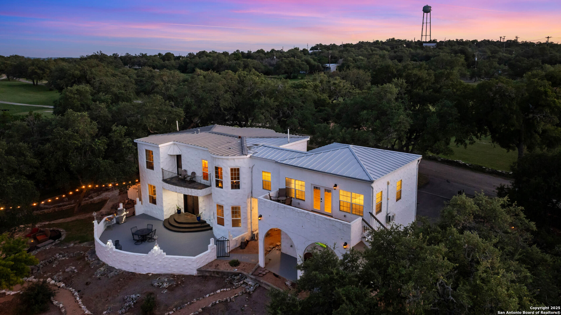 a aerial view of a house with a yard and a large tree