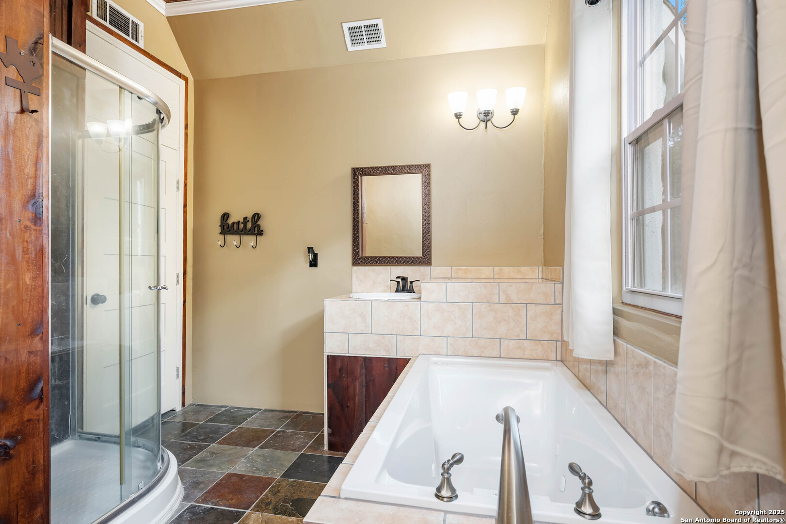 10655 Rebecca Creek Road Spring Branch, TX 78070 - Photo 25 of 34 a bathroom with a tub sink and mirror