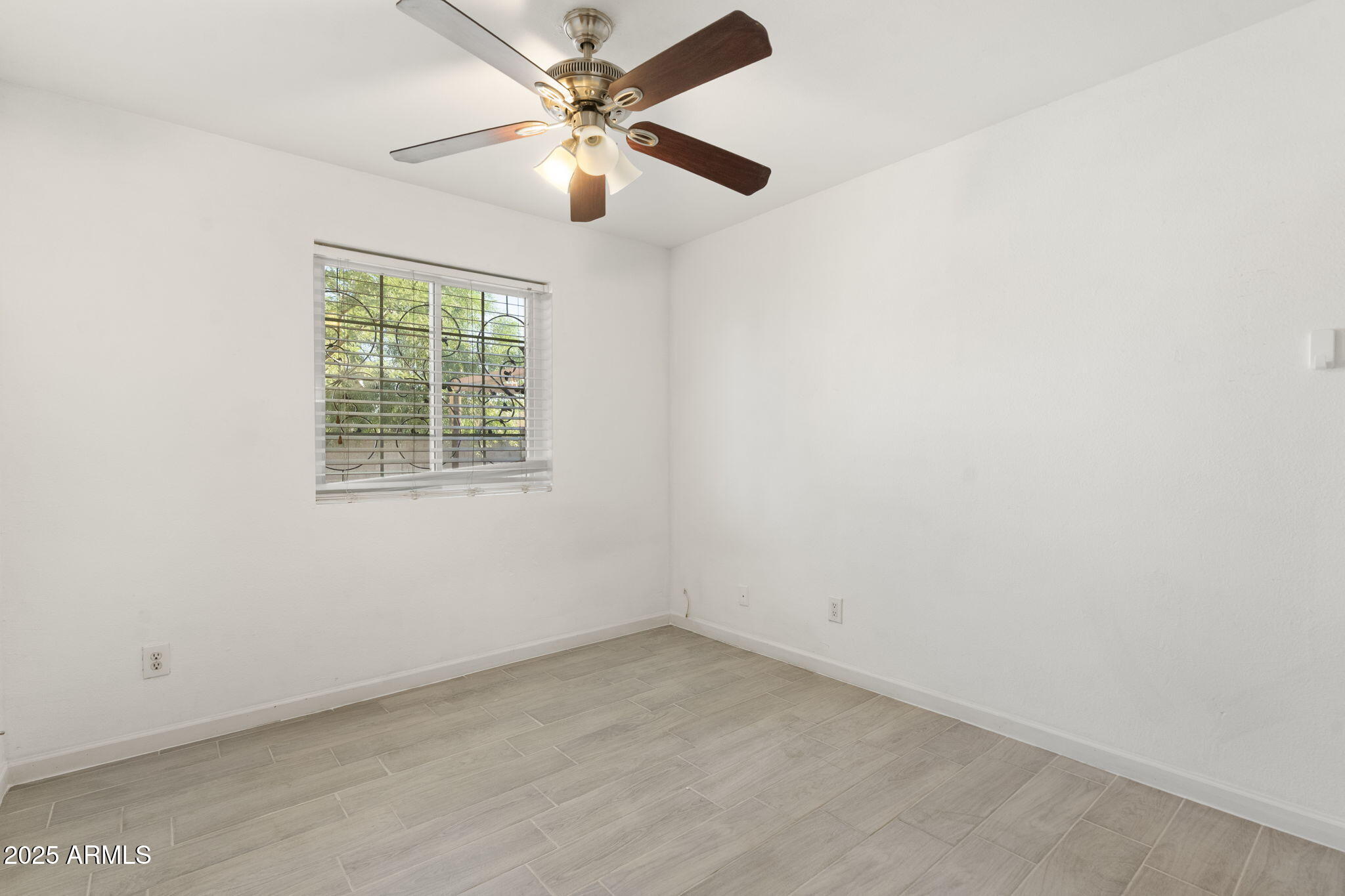 1121 West Halstead Drive Phoenix, AZ 85023 - Photo 14 of 22 an empty room with a window and a fan