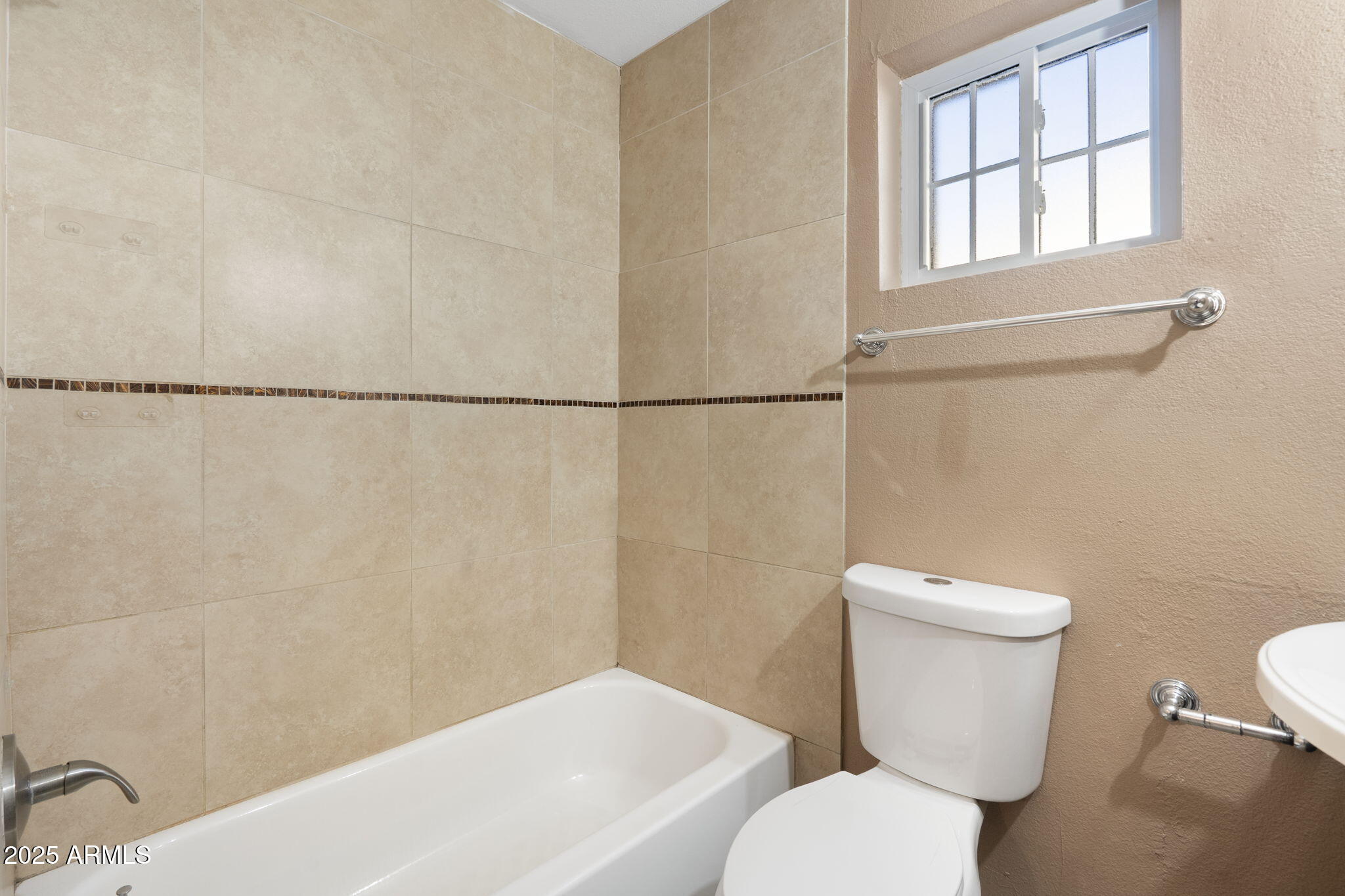 1121 West Halstead Drive Phoenix, AZ 85023 - Photo 18 of 22 a white toilet sitting next to a bathroom sink