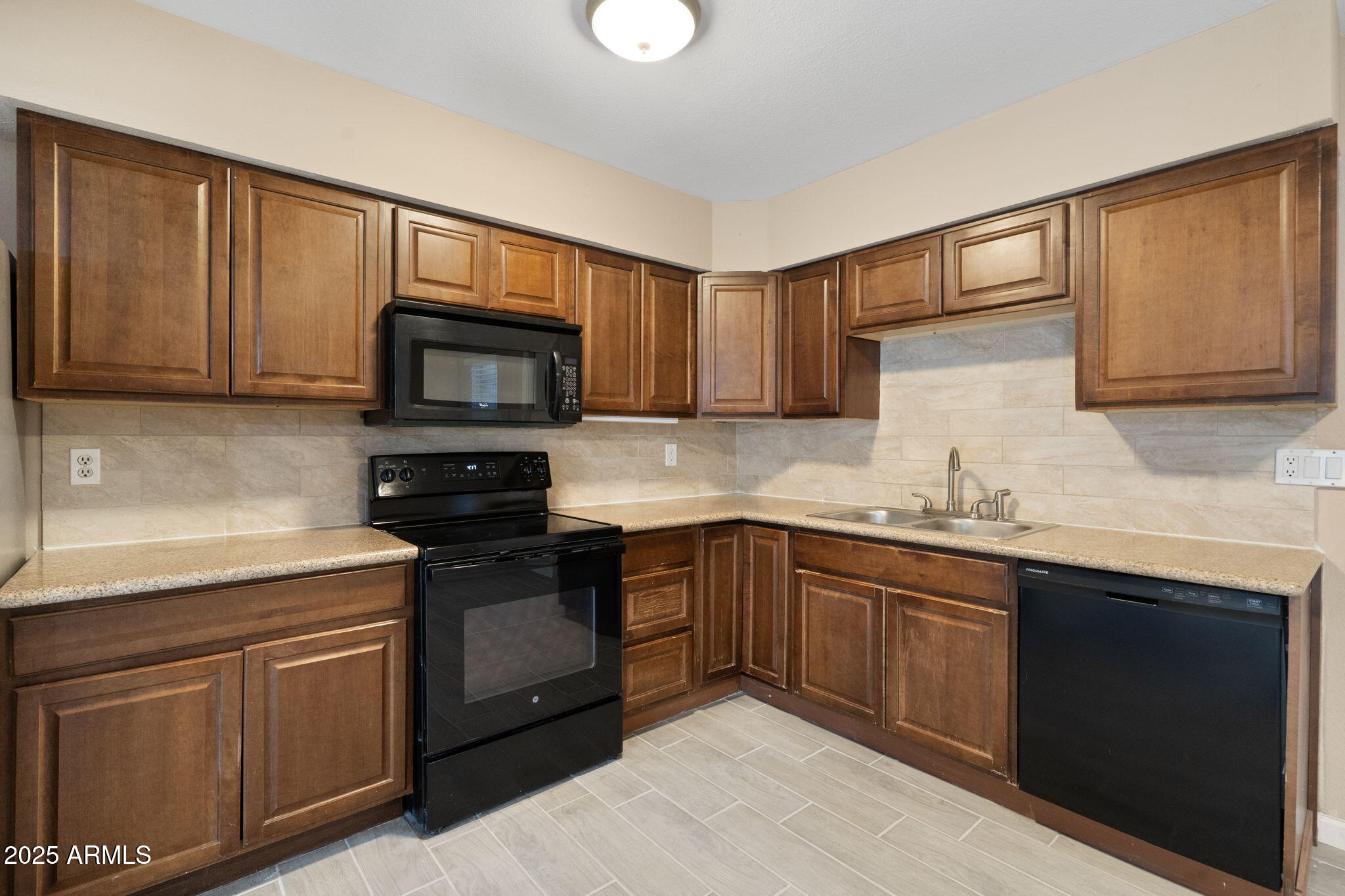 1121 West Halstead Drive Phoenix, AZ 85023 - Photo 9 of 22 a kitchen with granite countertop wooden cabinets and a stove top oven