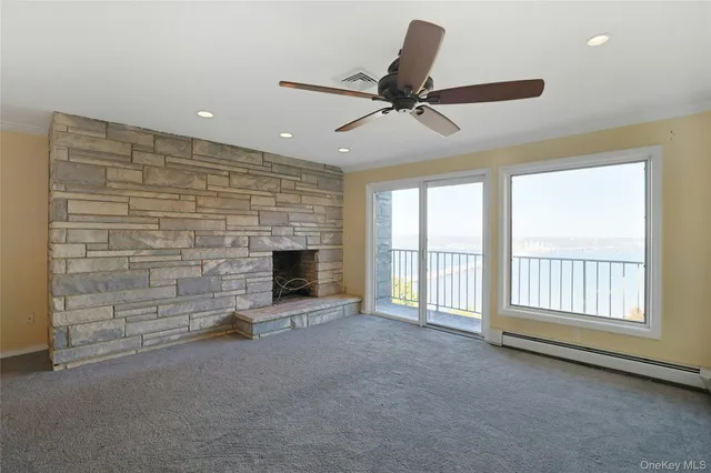 a view of an empty room with a fireplace and a window