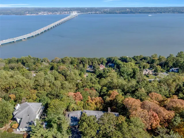 an aerial view of a house with a yard and lake view