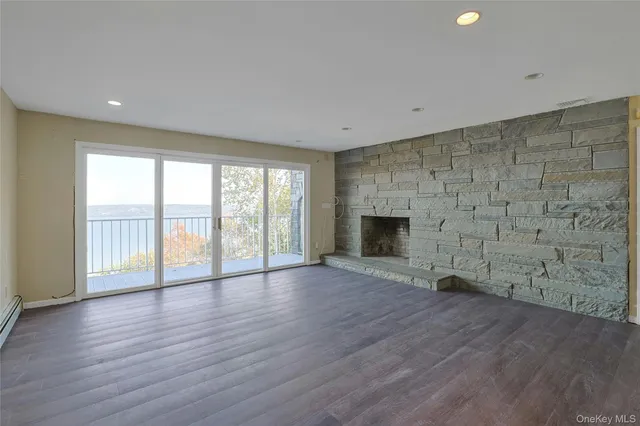 an empty room with wooden floor and fireplace