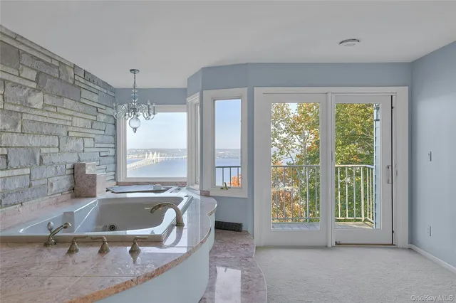 a bathroom with a tub a sink and large window