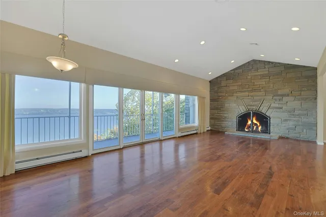 a view of empty room with wooden floor and fireplace