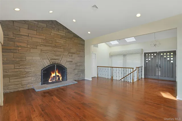 a view of an empty room with wooden floor fire place and a fireplace