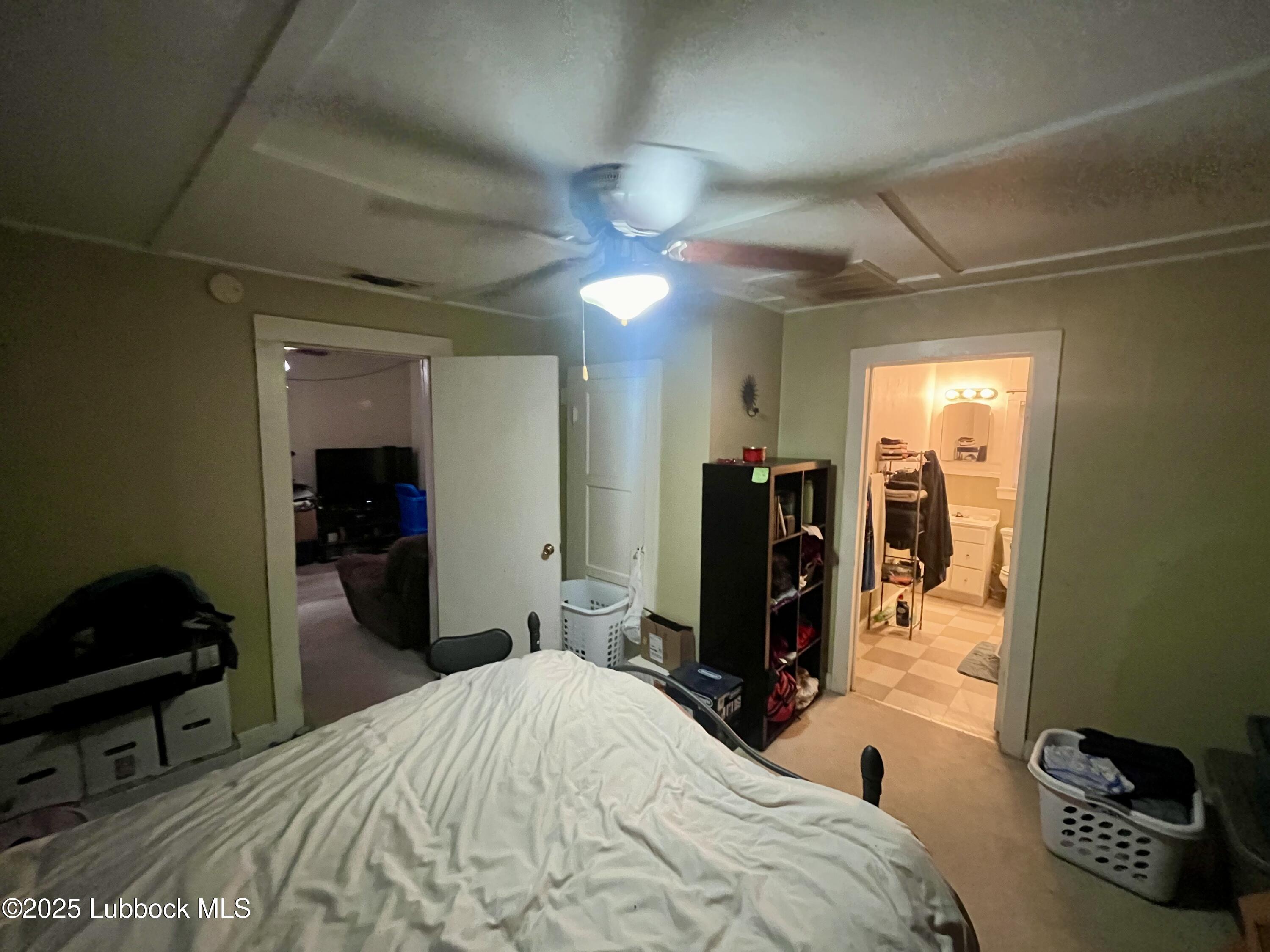 2819 35th Street Lubbock, TX 79413 - Photo 11 of 16 a bedroom with a bed and a chandelier