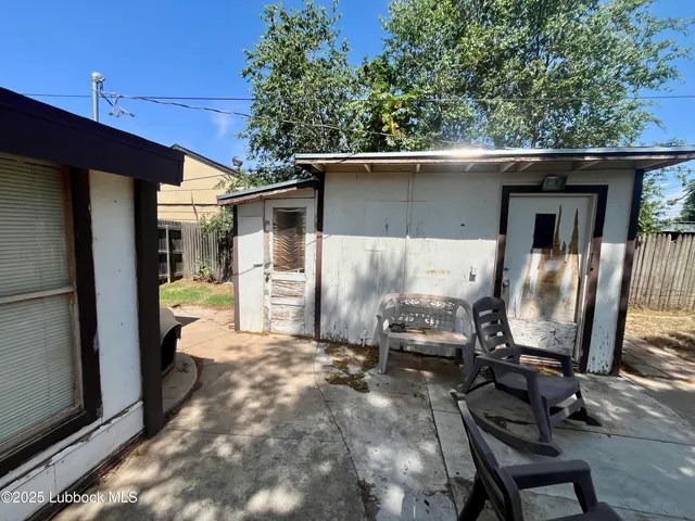 a view of a two chairs in the back yard of the house