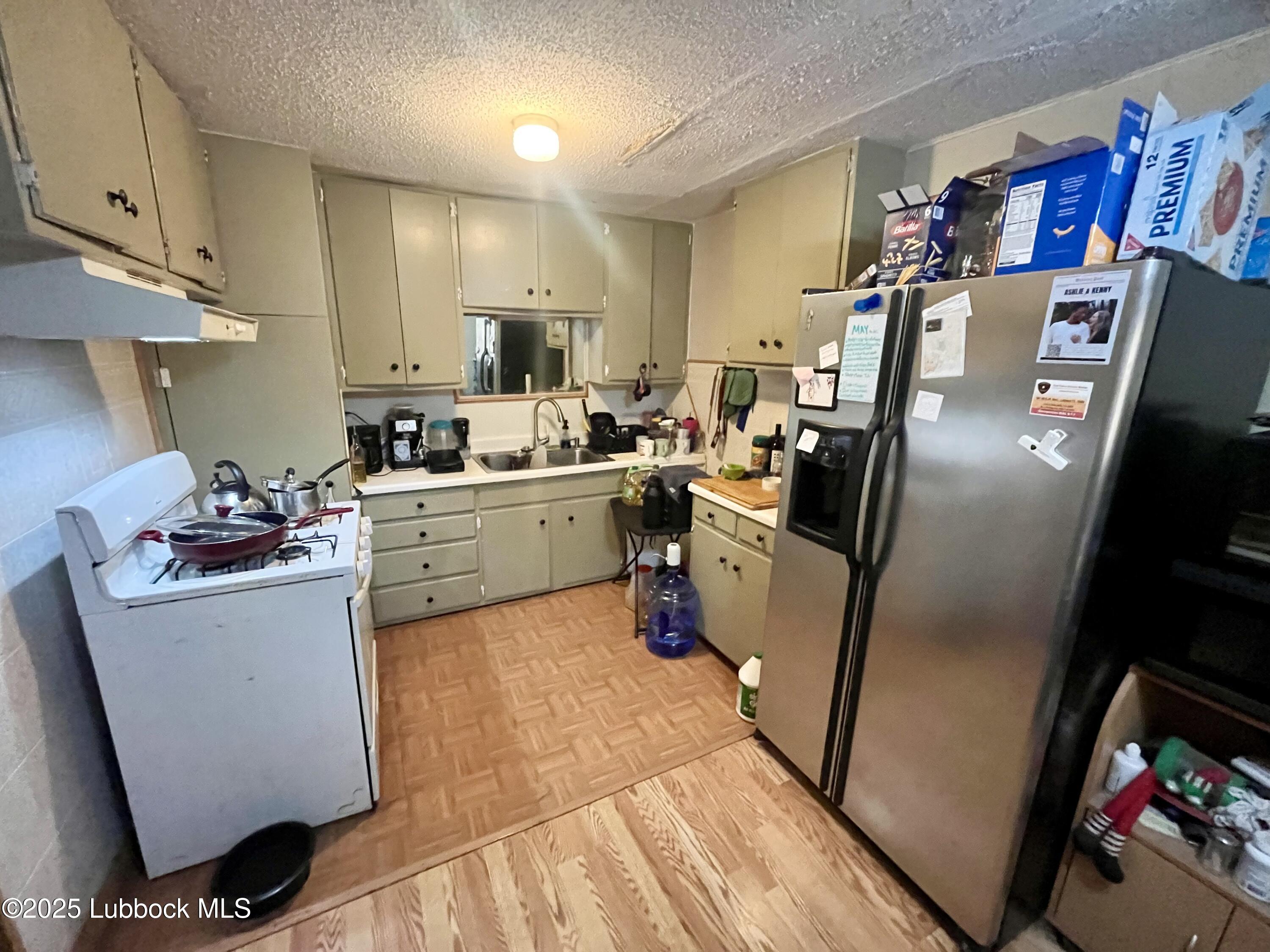 2819 35th Street Lubbock, TX 79413 - Photo 5 of 16 a view of a kitchen with fridge and workspace