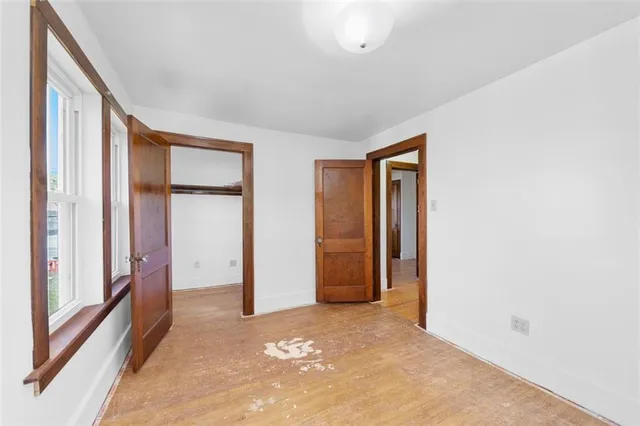 a view of an empty room with closet and a window