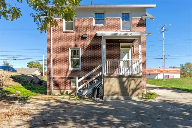 a view of a house with large windows and a small yard