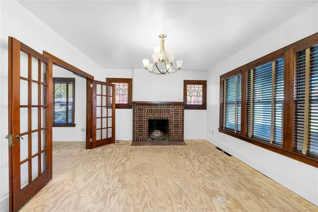 a view of an empty room with a fireplace and a window