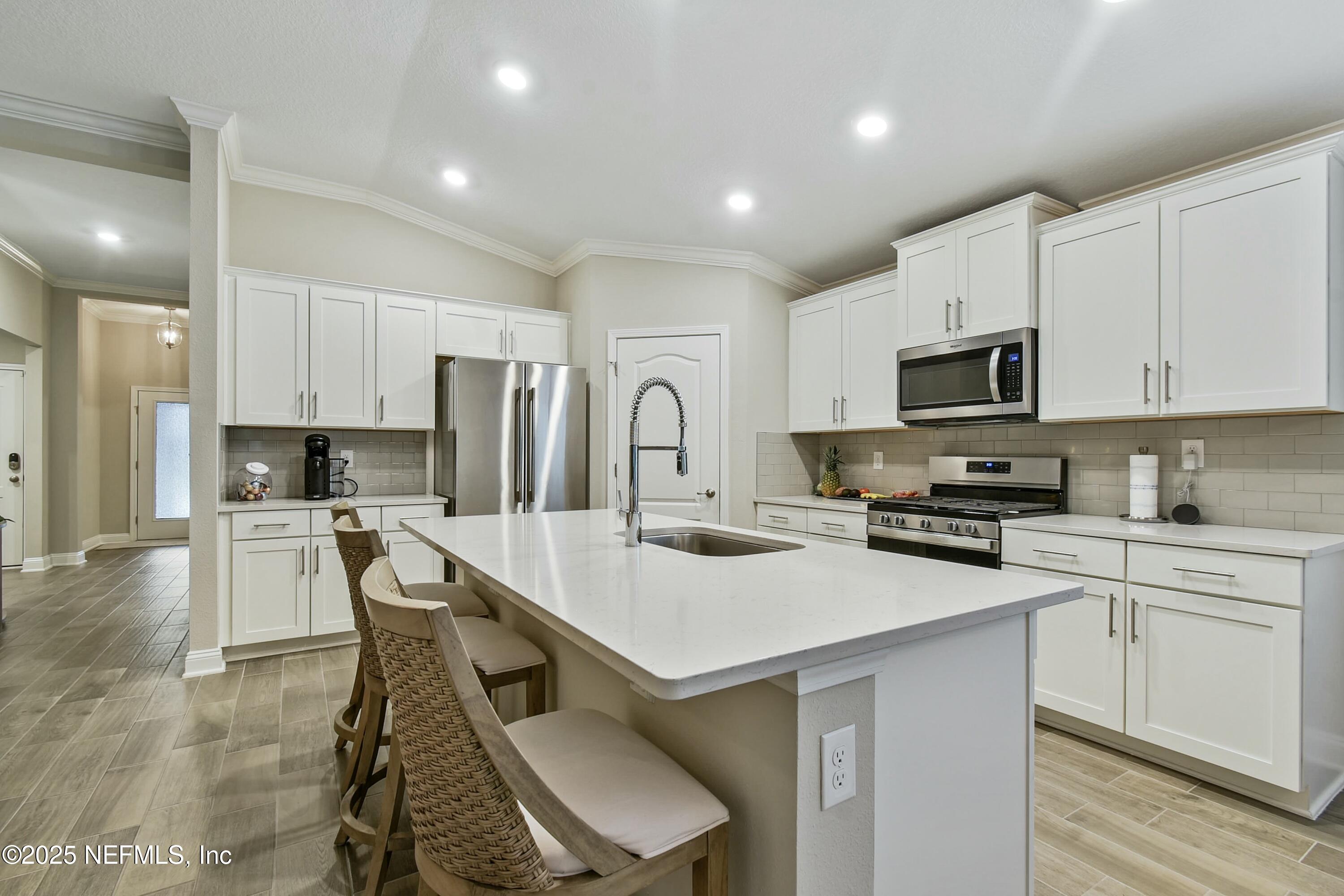 1399 Parkland Trail St. Augustine, FL 32095 - Photo 12 of 39 a kitchen with white cabinets stainless steel appliances and sink