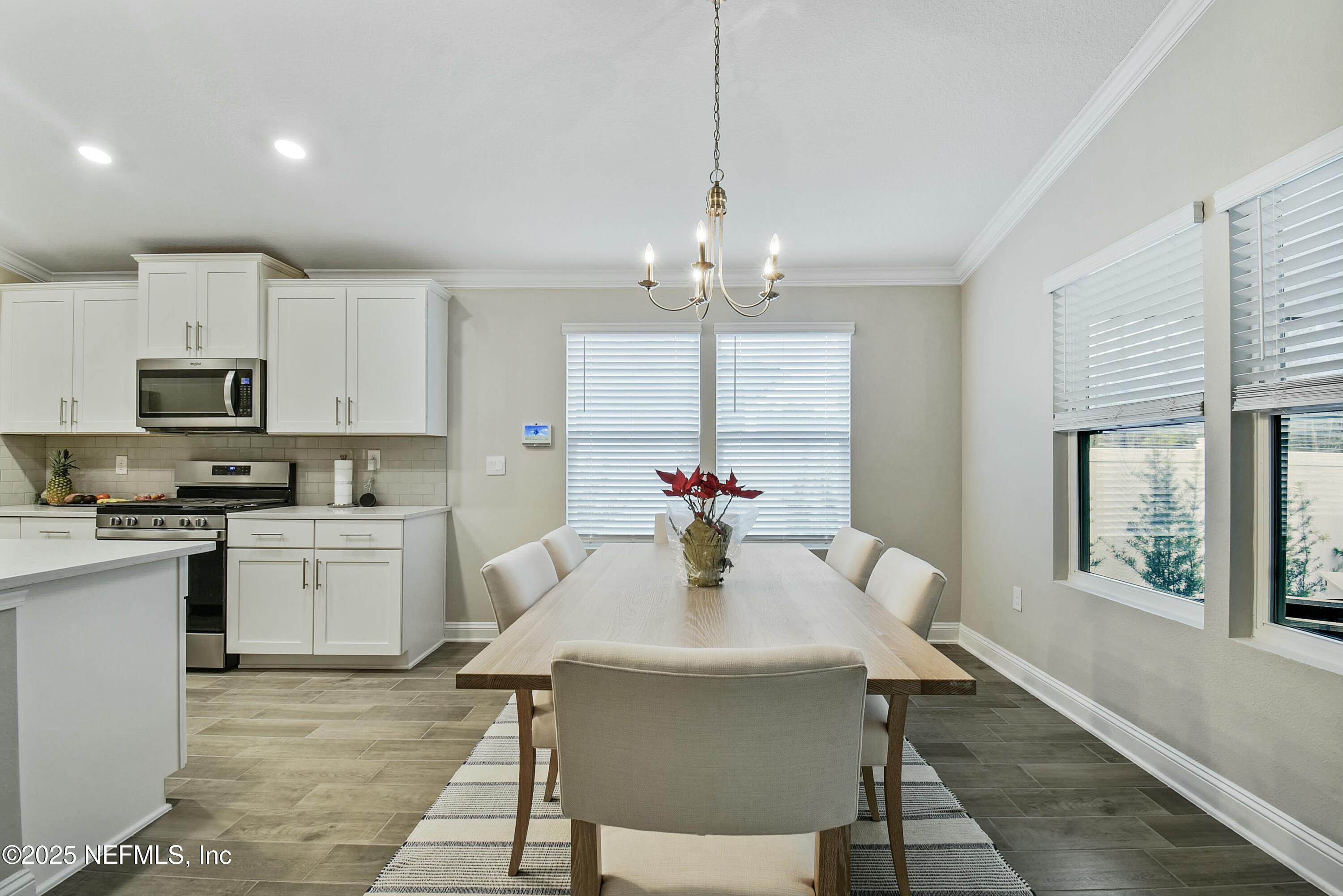 1399 Parkland Trail St. Augustine, FL 32095 - Photo 13 of 39 a kitchen with a dining table chairs stainless steel appliances and cabinets