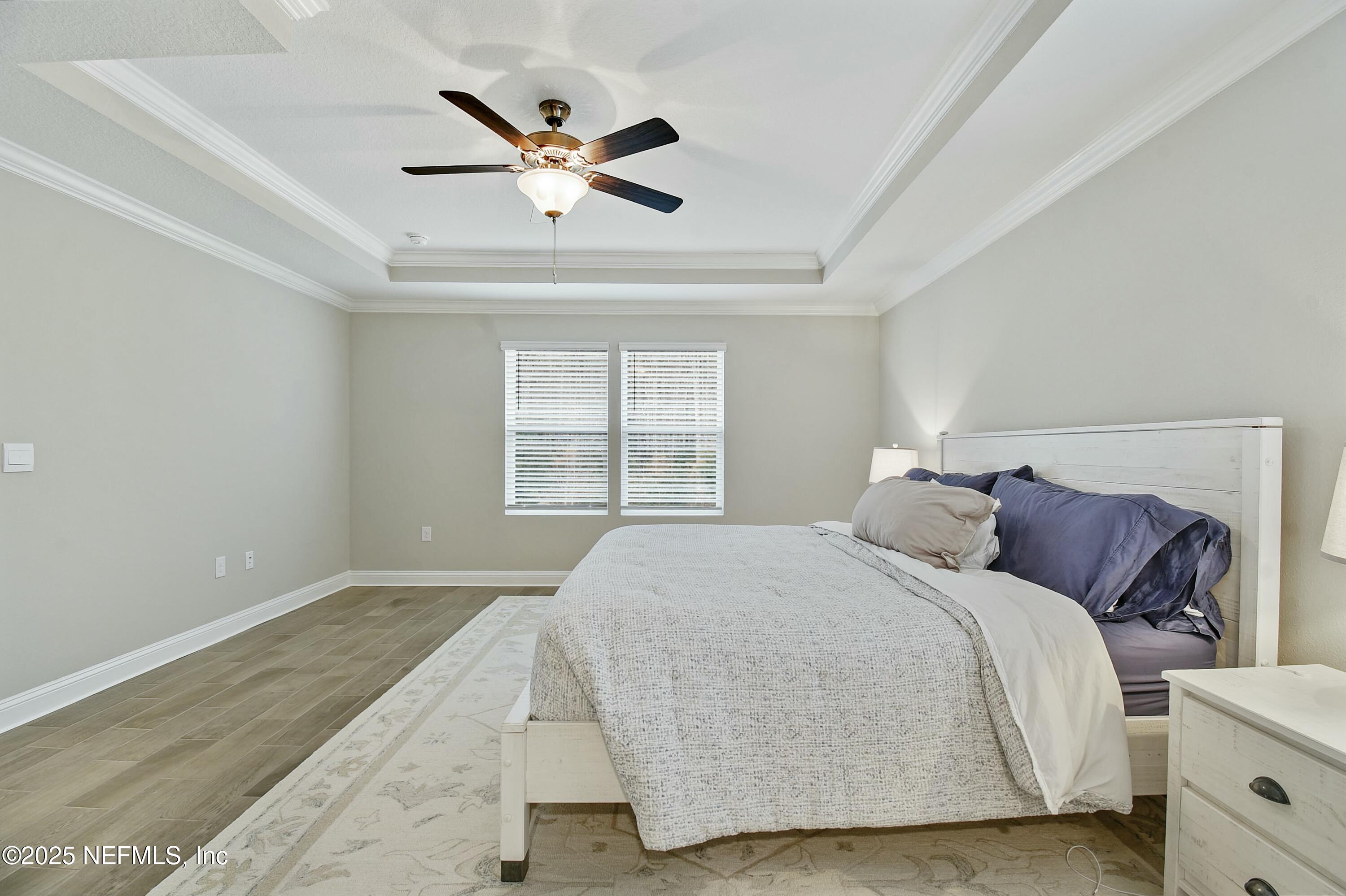 1399 Parkland Trail St. Augustine, FL 32095 - Photo 17 of 39 a bedroom with a large bed and a chandelier