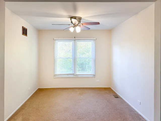 an empty room with a window and a fan