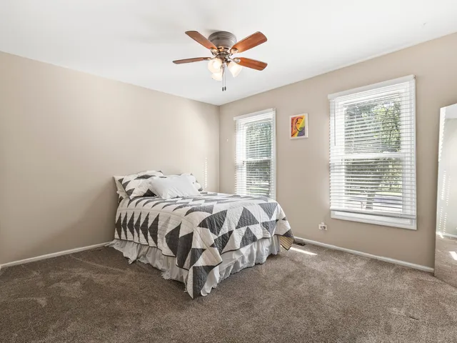 a bed sitting in a spacious bedroom next to a window