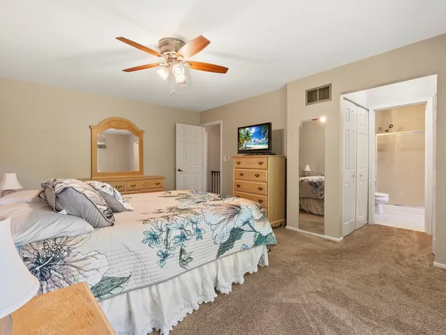 a bedroom with a bed and ceiling fan