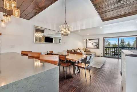a dining room with furniture a chandelier and wooden floor