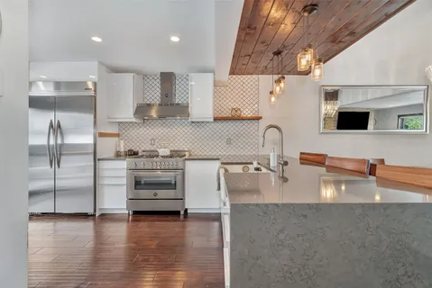 a kitchen with stainless steel appliances granite countertop a sink and a stove