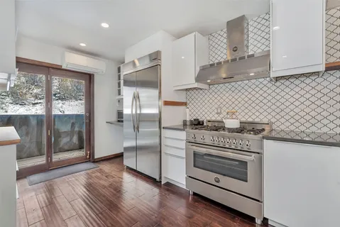a kitchen with granite countertop a stove and a refrigerator