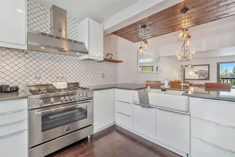 a kitchen with white cabinets and appliances