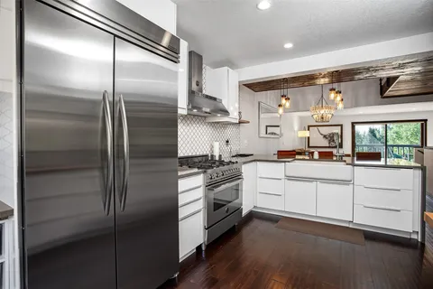a kitchen with stainless steel appliances cabinets and a large window