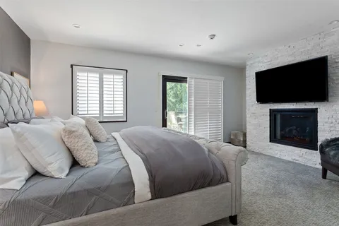 a spacious bedroom with a bed and a flat screen tv