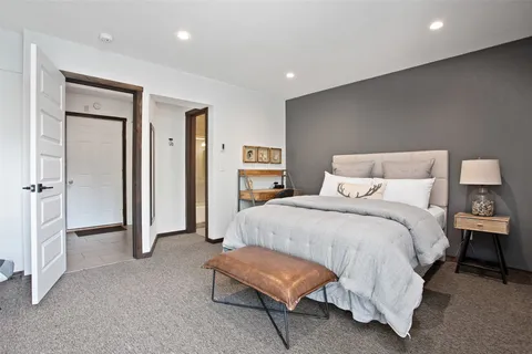 a spacious bedroom with a bed and a chair