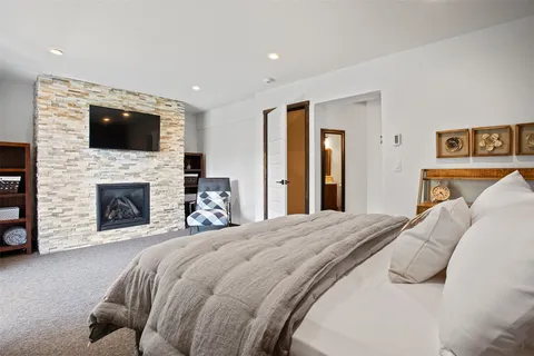 a bedroom with a large bed and a fireplace