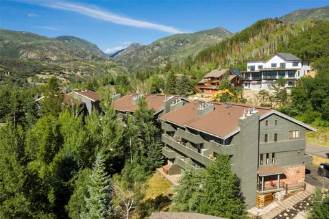 an aerial view of residential houses with outdoor space and trees