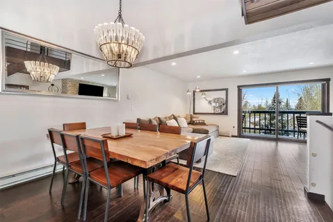 a view of a dining room with furniture a chandelier and wooden floor