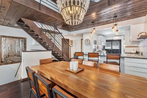 a dining room with wooden floor table and chairs