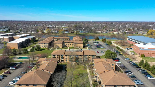 an aerial view of a city with lots of residential buildings ocean and mountain view in back