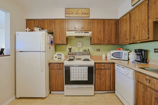 a kitchen with a refrigerator sink and cabinets