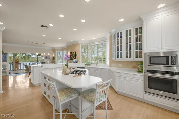 a kitchen with stainless steel appliances granite countertop a stove top oven a sink a dining table and chairs