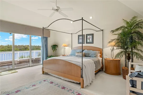 a bedroom with a large bed and a potted plant