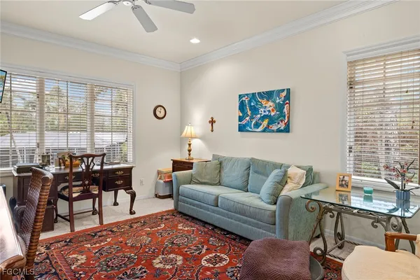 a living room with furniture two window and a dining table