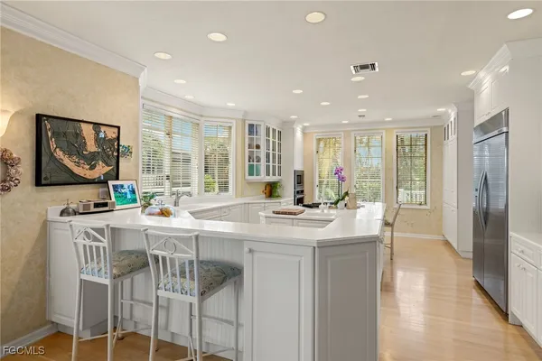 a view of a kitchen with kitchen island granite countertop a large counter top space and stainless steel appliances