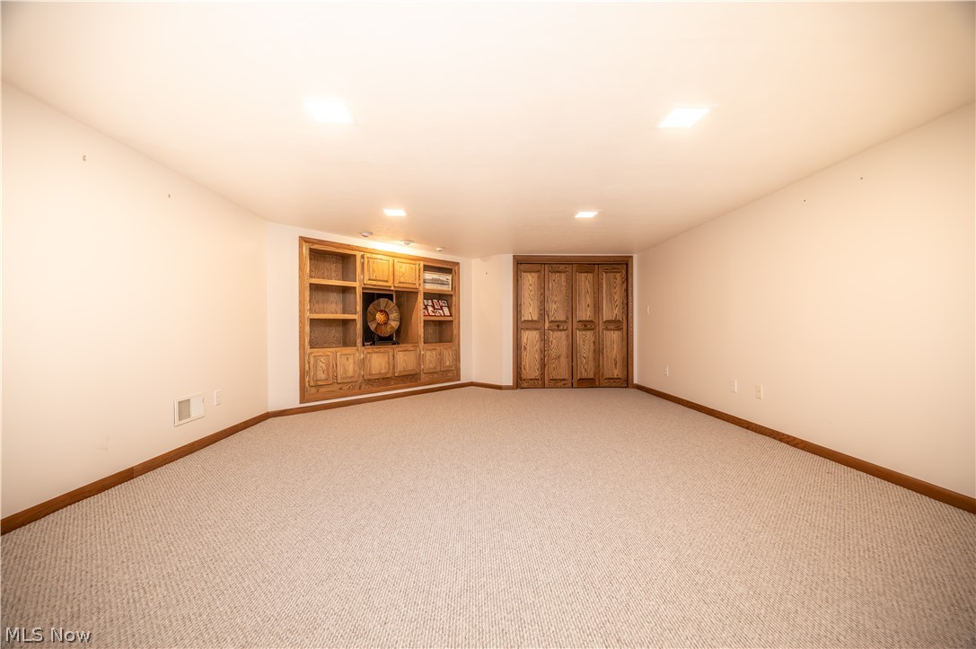 405 Airport Road Northwest Warren, OH 44481 - Photo 36 of 50 Carpeted bonus room in lower level complete with built-in shelves, cabinets, and closet.