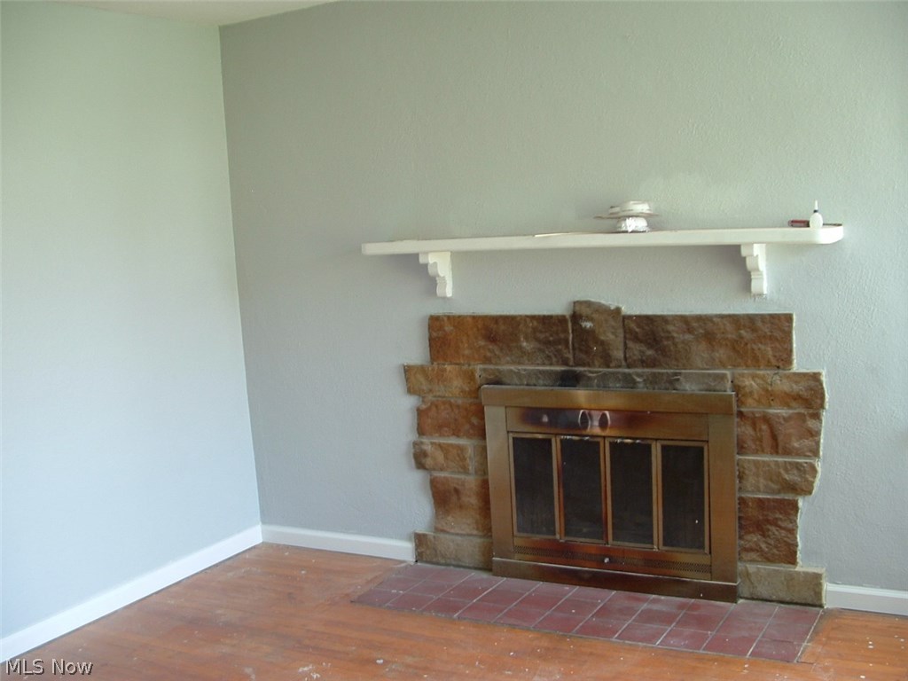 Wood burning fireplace in great room.  Walls painted in 2017.  wall-to-wall carpeting has been removed and original hardwood flooring is ready to be re-finished and stained.