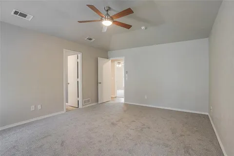 an empty room with closet and a chandelier fan