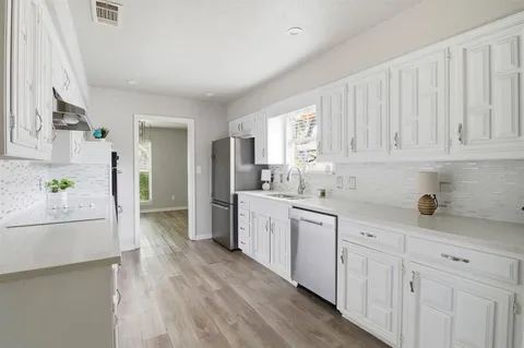 a kitchen with granite countertop white cabinets and white appliances