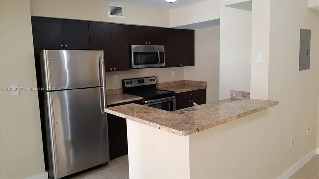 a kitchen with stainless steel appliances granite countertop a refrigerator and a stove top oven