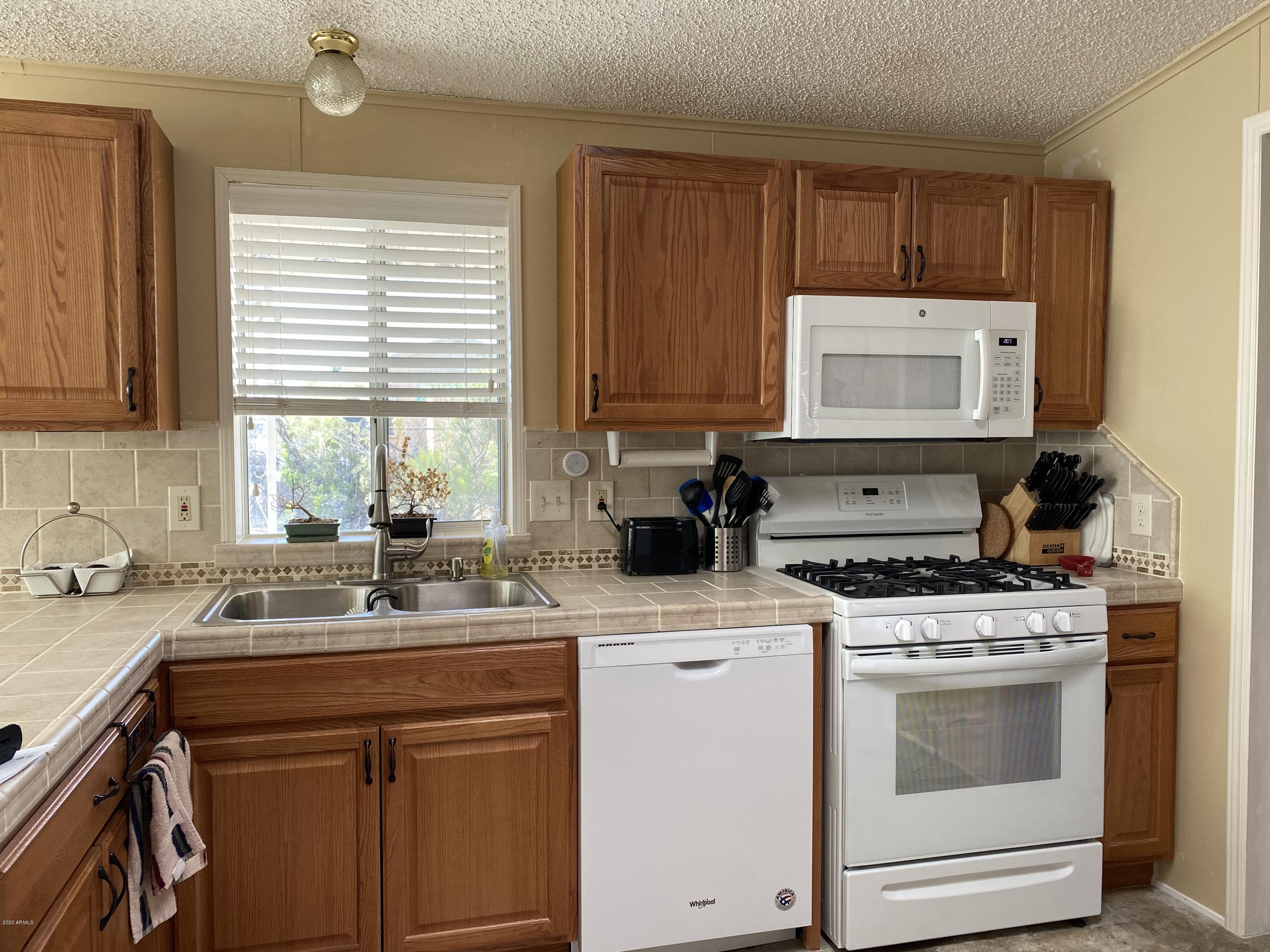 202 North Hawes Road Mesa, AZ 85207 - Photo 8 of 27 a kitchen with a stove a sink and a microwave