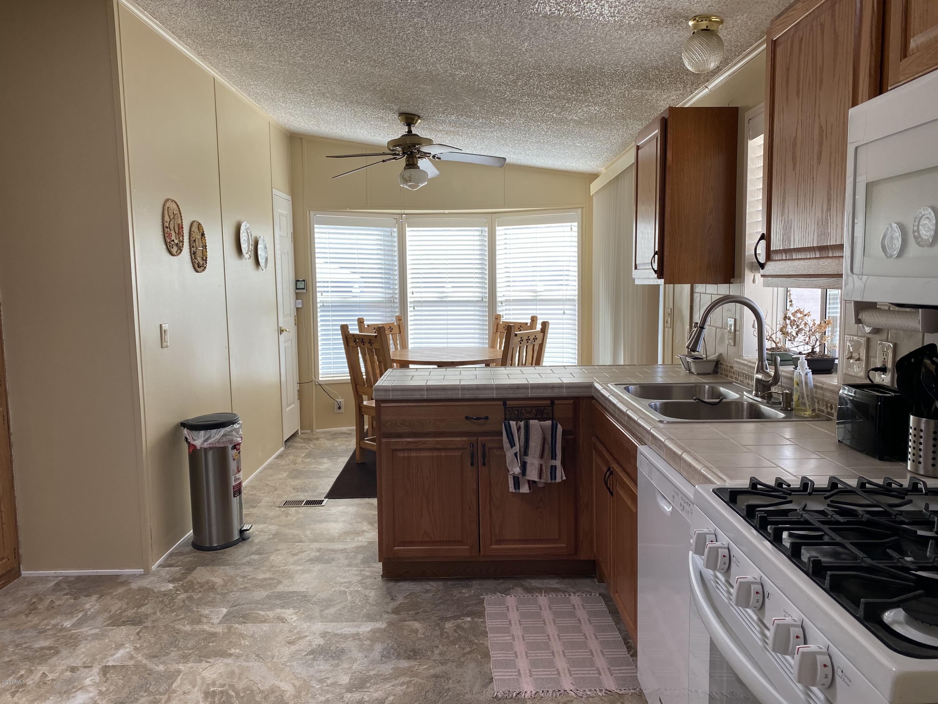 202 North Hawes Road Mesa, AZ 85207 - Photo 9 of 27 a kitchen with stainless steel appliances granite countertop a sink stove and cabinets